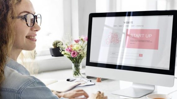 woman smiling while working on her computer