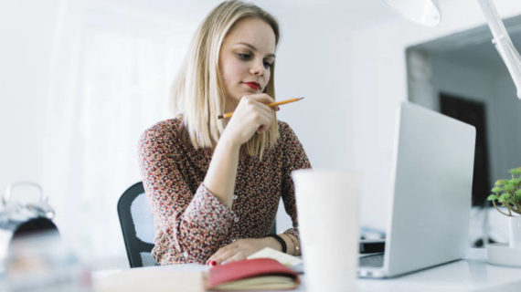 woman thinking while looking at her laptop