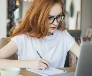 red hair woman writing on her notebook
