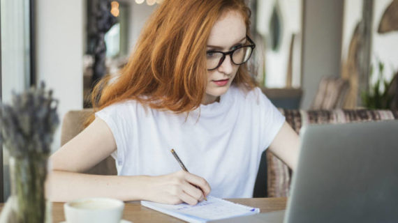red hair woman writing on her notebook