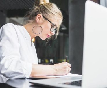 woman writing on documents