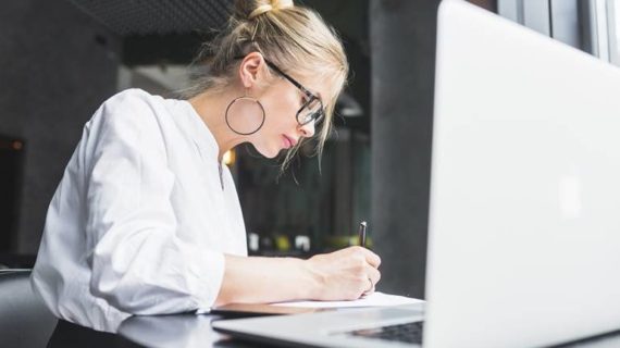 woman writing on documents