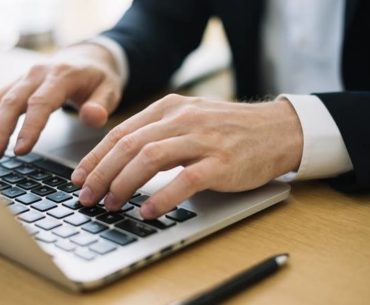 man typing on his laptop