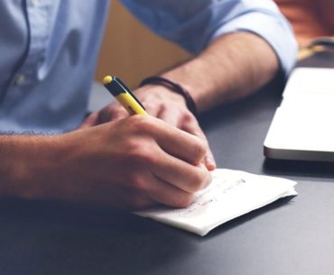 man writing notes