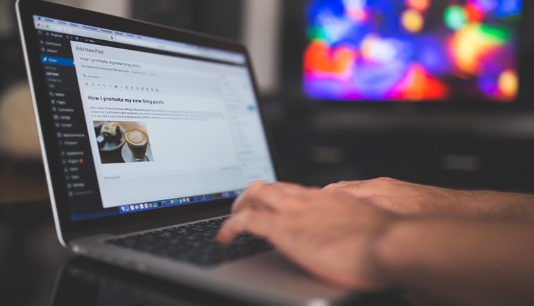 man typing on laptop keyboard