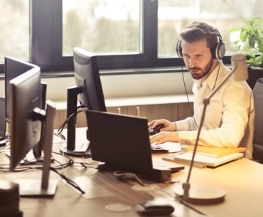 man with headphone facing computer