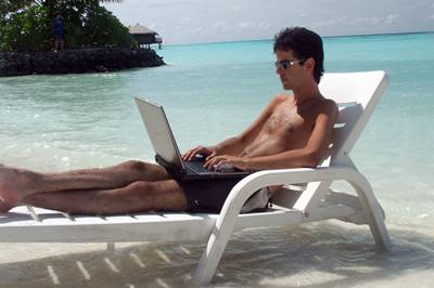 man working on his laptop at the beach
