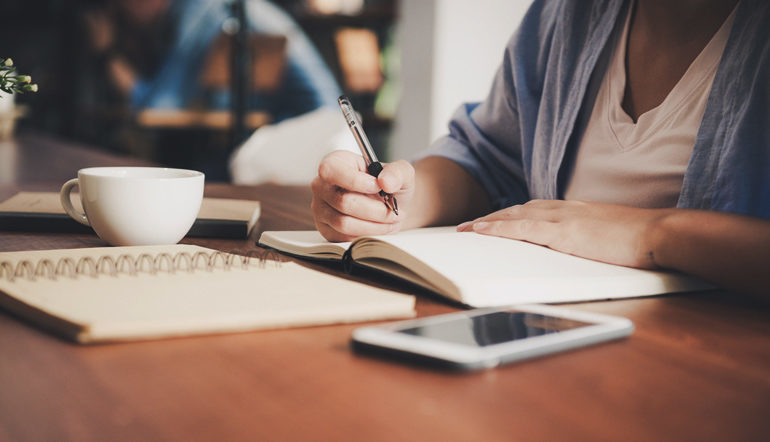 woman writing on a notebook