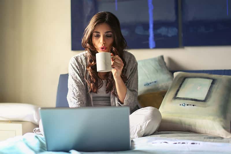 Girl drinking coffe staring at computer