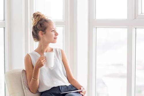 woman holding a white cup