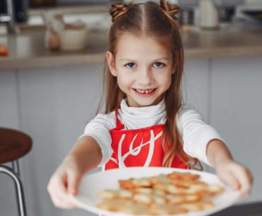 adorable little girl holding plate of cookies