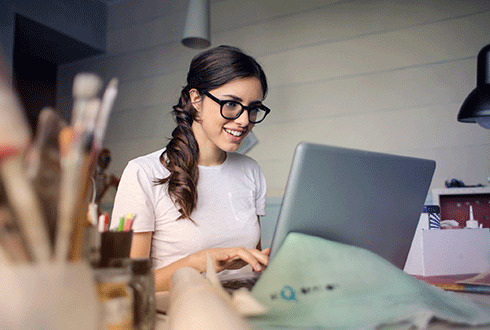 happy young woman using her laptop