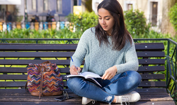 young woman writing on her notebook