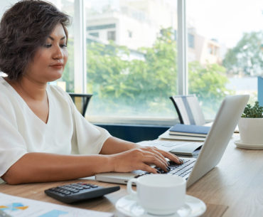 woman with short wavy hair sitting desk office