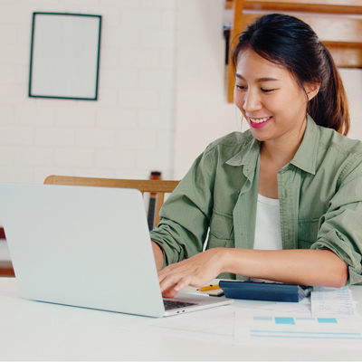 happy young female adult typing on her laptop