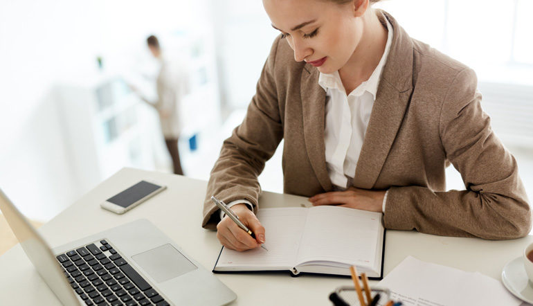 adult female employee writing on her notebook