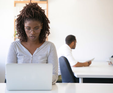 beautiful black woman working using her silver laptop