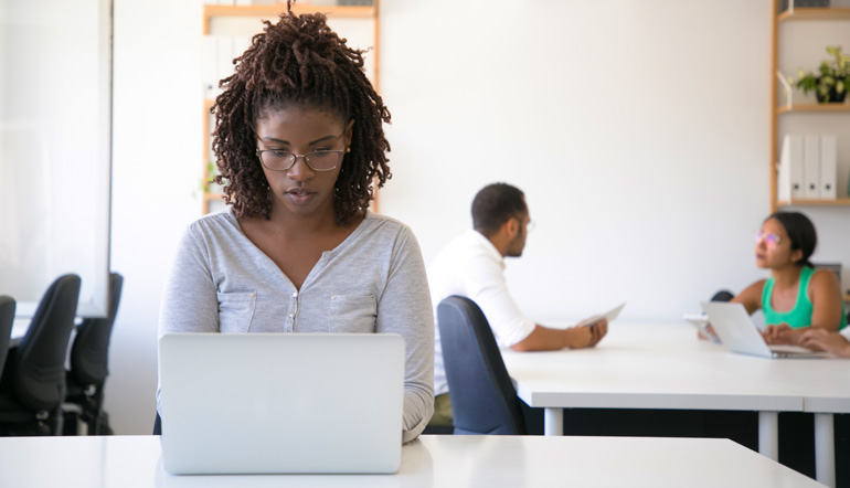 beautiful black woman working using her silver laptop