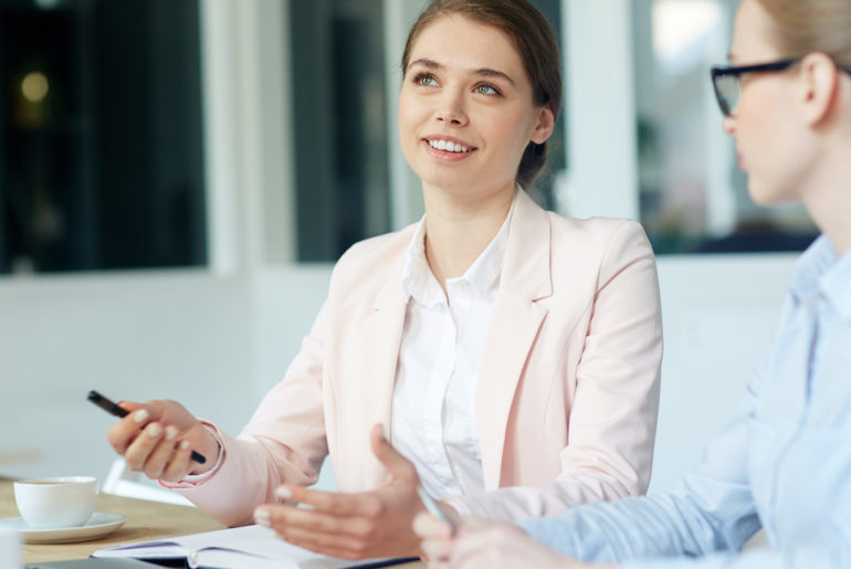 women smiling while discussing