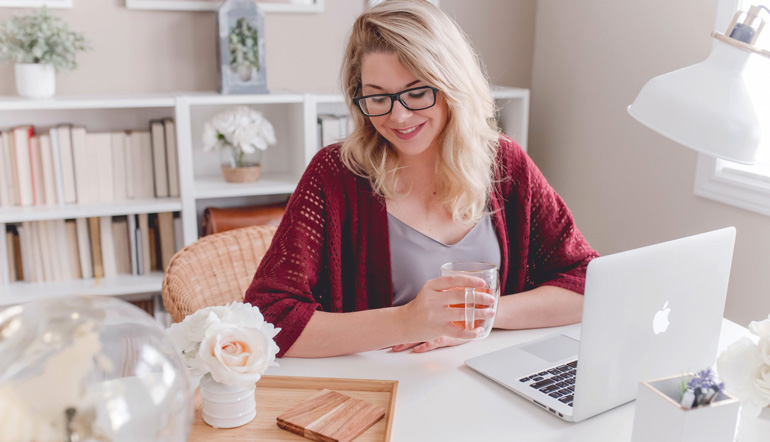 young female working while drinking tea