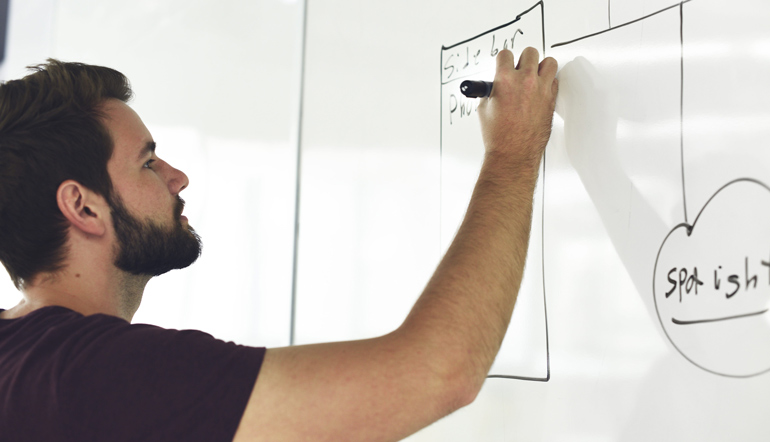 man holding black pen wearing black crew-neck