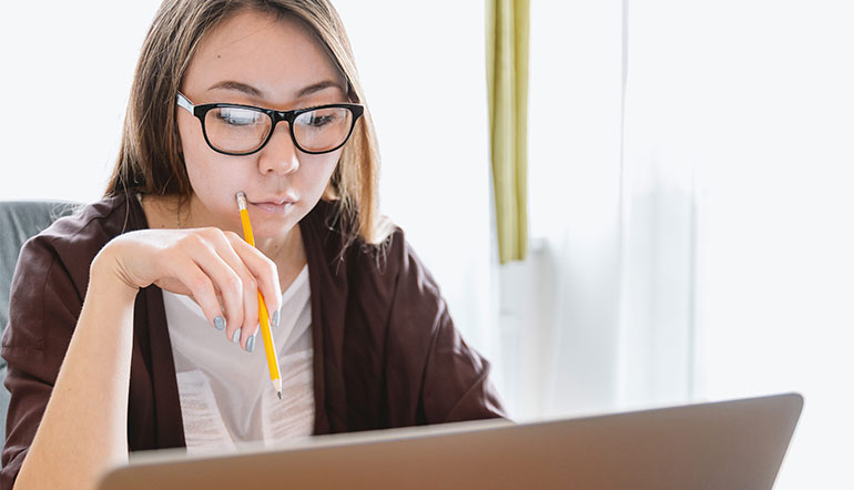 Woman reading notes on her laptop