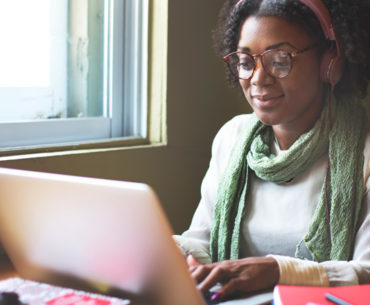 african woman working using her silver laptop