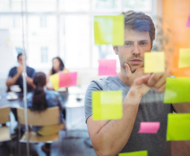 Close-up of male executive reading sticky notes