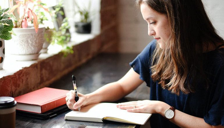 woman writing on her notebook