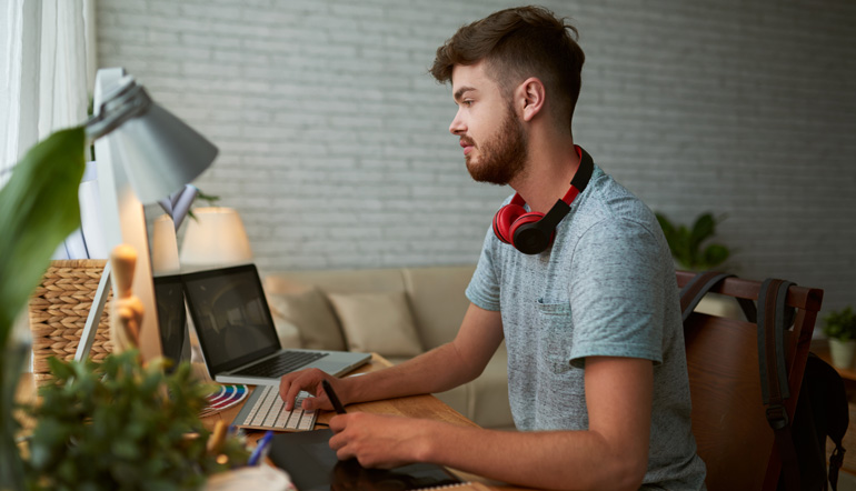 Side view of young student doing homework for design class