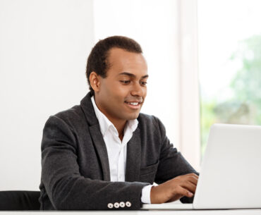 Young successful businessman typing on laptop