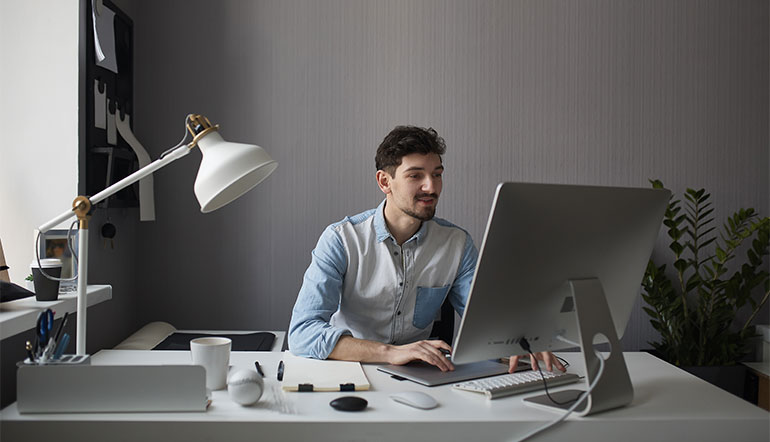 Young man working with his desktop computer