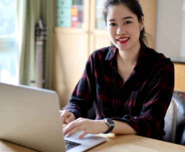 cheerful young woman working using her laptop