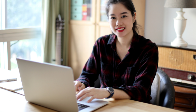 cheerful young woman working using her laptop