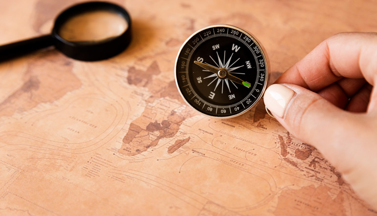 hand holding a compass on a map