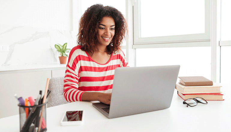 cheerful woman using silver laptop