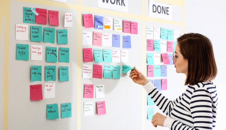 young woman near scrum task board in office