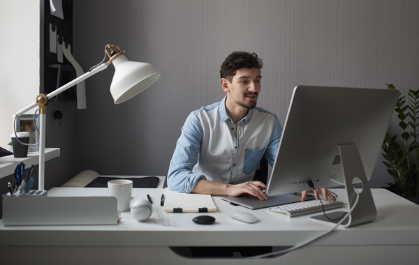 young male working using computer