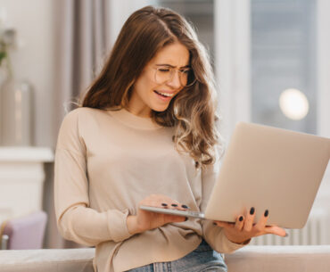 cheerful young woman holding a laptop
