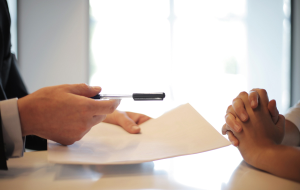 Businessman giving cotract to woman to sign