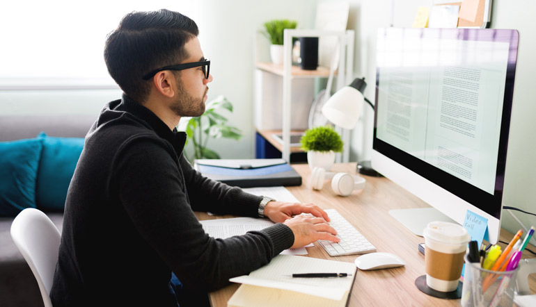 male writer typing on the computer