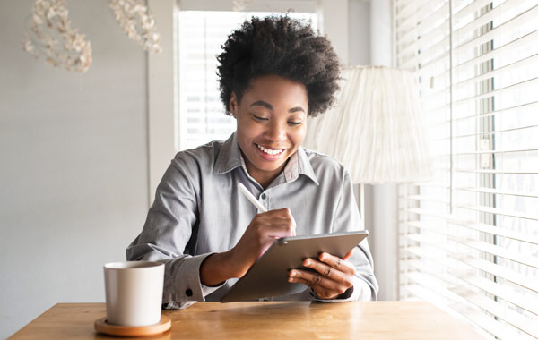 woman writing on her tablet