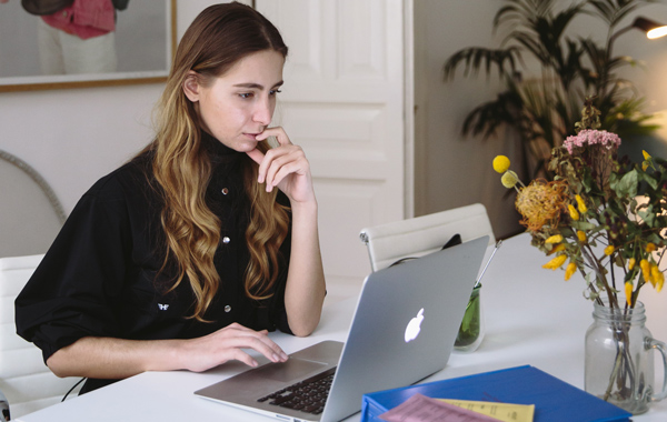 Woman looking thoughtfully at a laptop