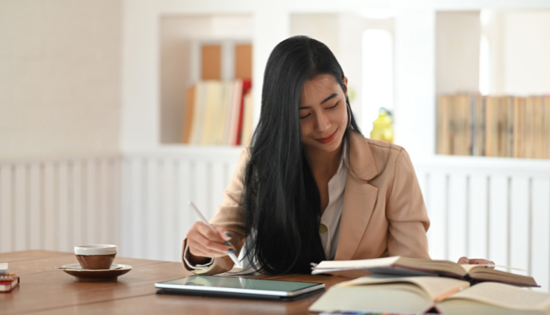 Editor Female Reading Book with Using Tablet and Stylus Pen