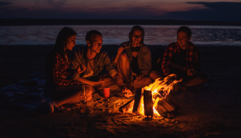 group of people having bonfire near the beach