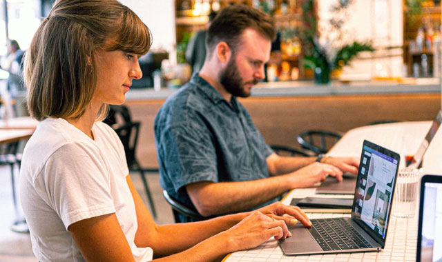 man and woman working on laptops