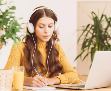happy female in wireless headphones studying online course