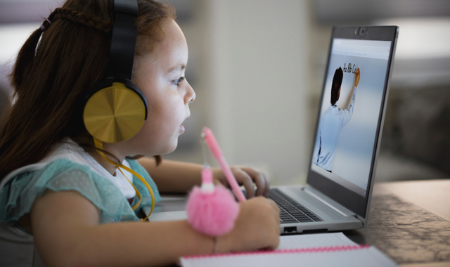 little girl attending to online school class