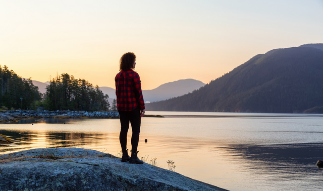 girl watching a peaceful sunrise on the ocean coast