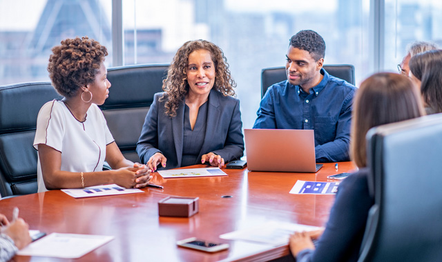 group of people sitting around a table conversing